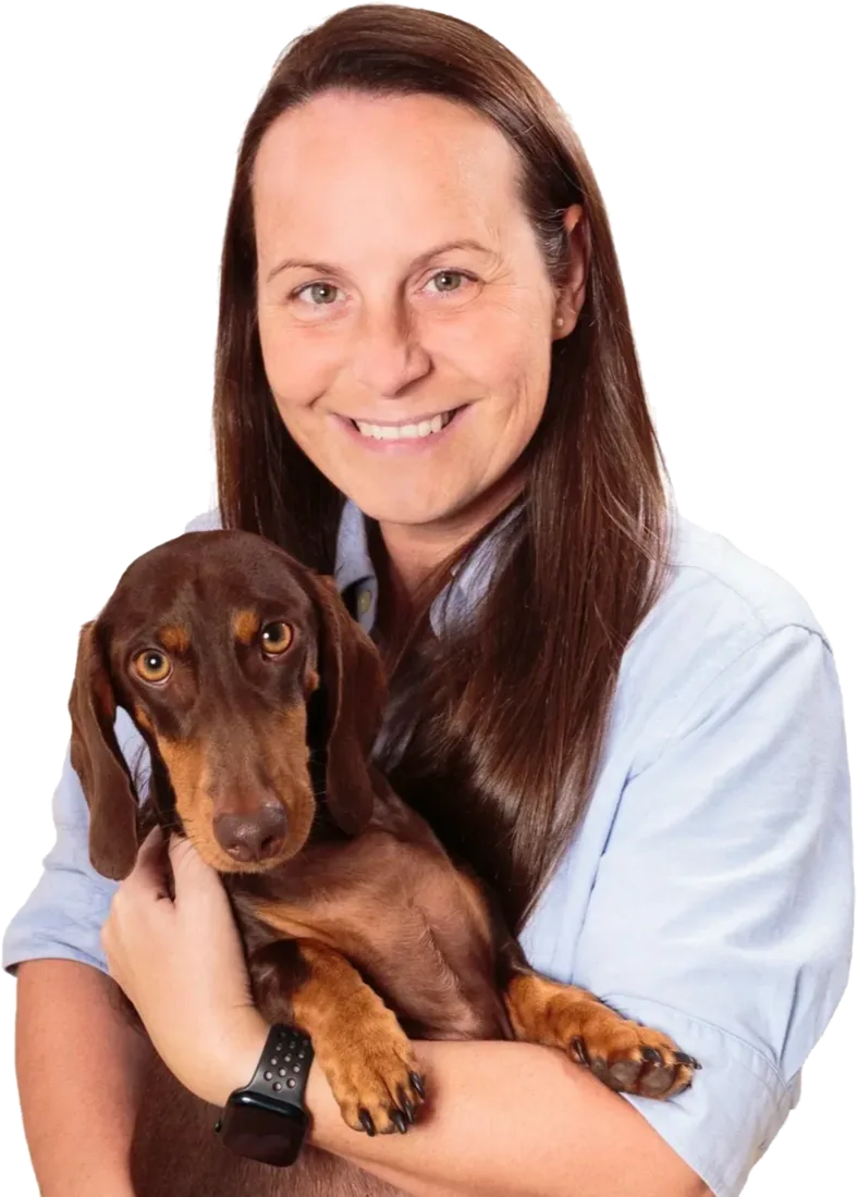 Kelly, founder of Gunners Goodies, holding Gunner the dachshund