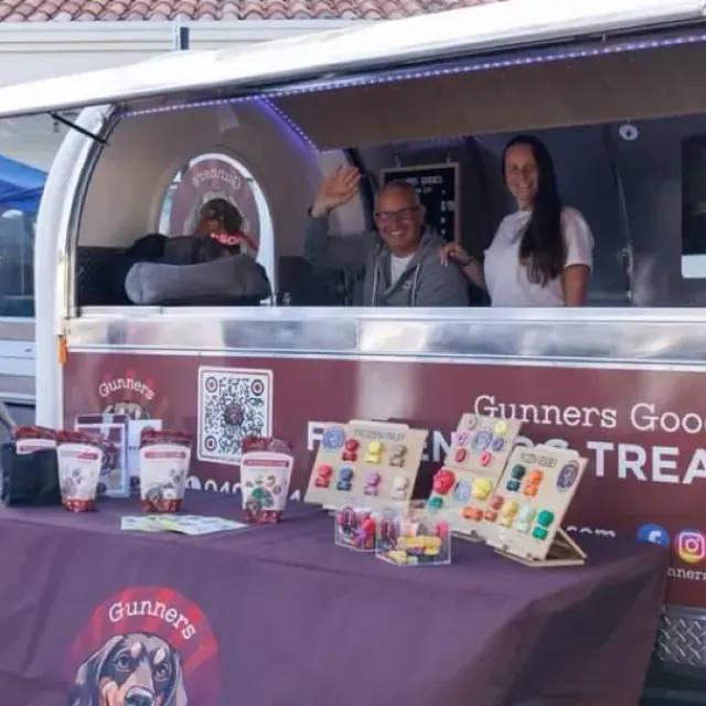 Kelly and the team waving from inside the Gunners Goodies trailer